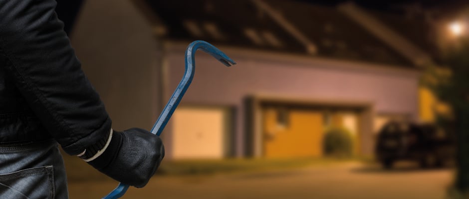 Allianz Handwerkerservice: Unsere Leistungen bei Einbruch­schäden. Ein Dieb oder eine Diebin geht mit Eisenstange in der Hand auf ein Haus zu.